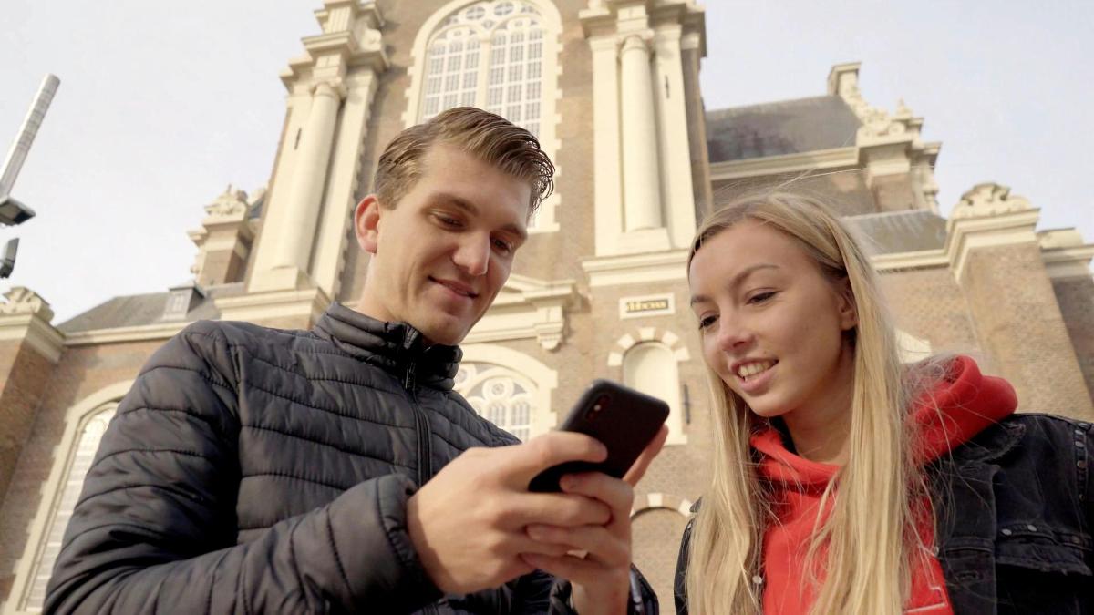 muž a žena se dívají na mobilní telefon
