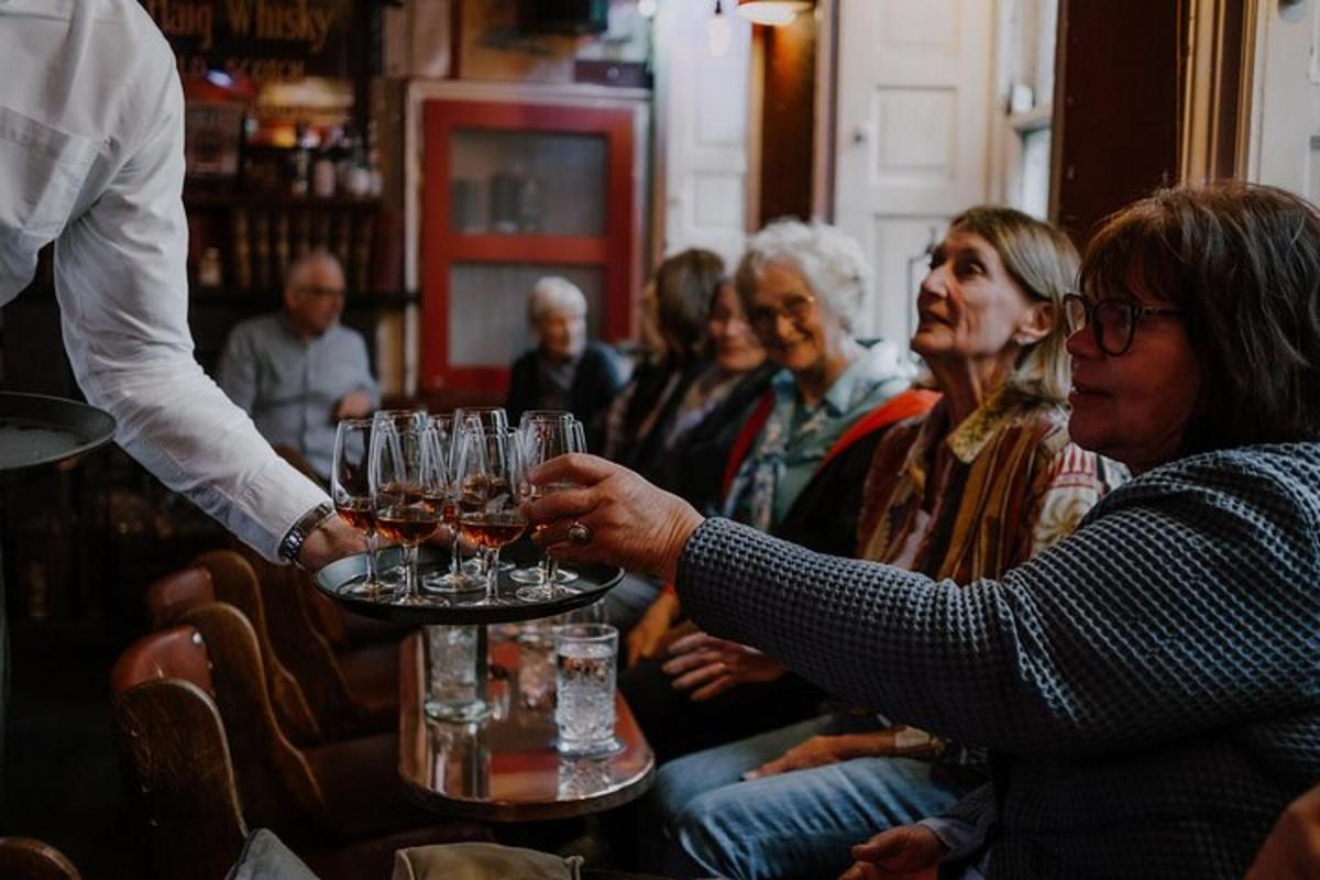 uma pessoa segurando uma bandeja com taças de vinho