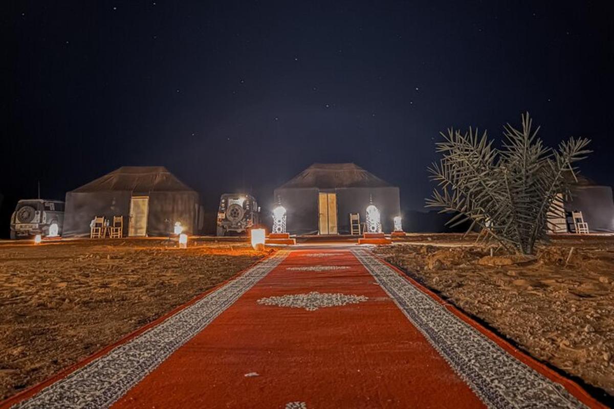 un camí davant de dues cabanes a la nit