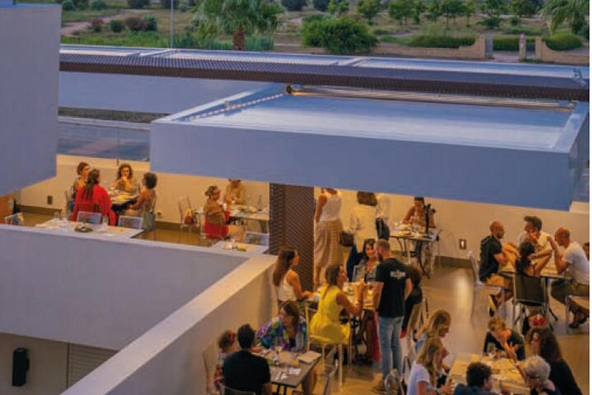 en gruppe mennesker som sitter ved bordene på en restaurant