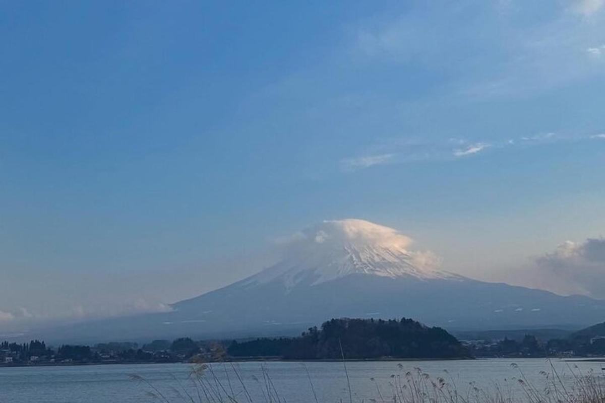 una montagna coperta di neve sullo sfondo di uno specchio d'acqua