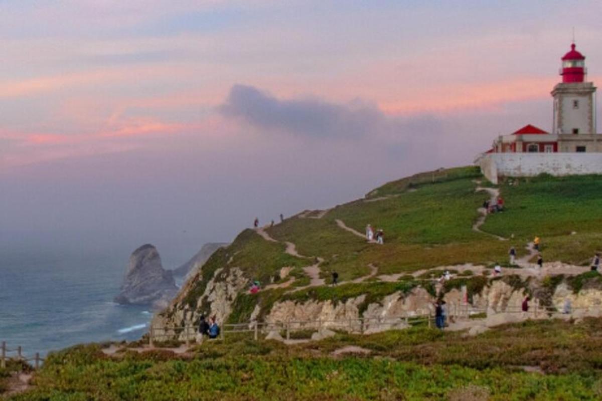 a lighthouse on top of a cliff near the ocean