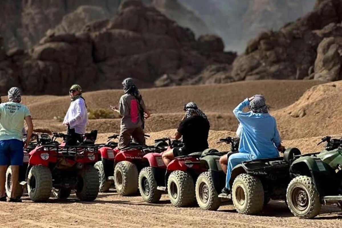sekelompok orang mengendarai ATV di padang pasir