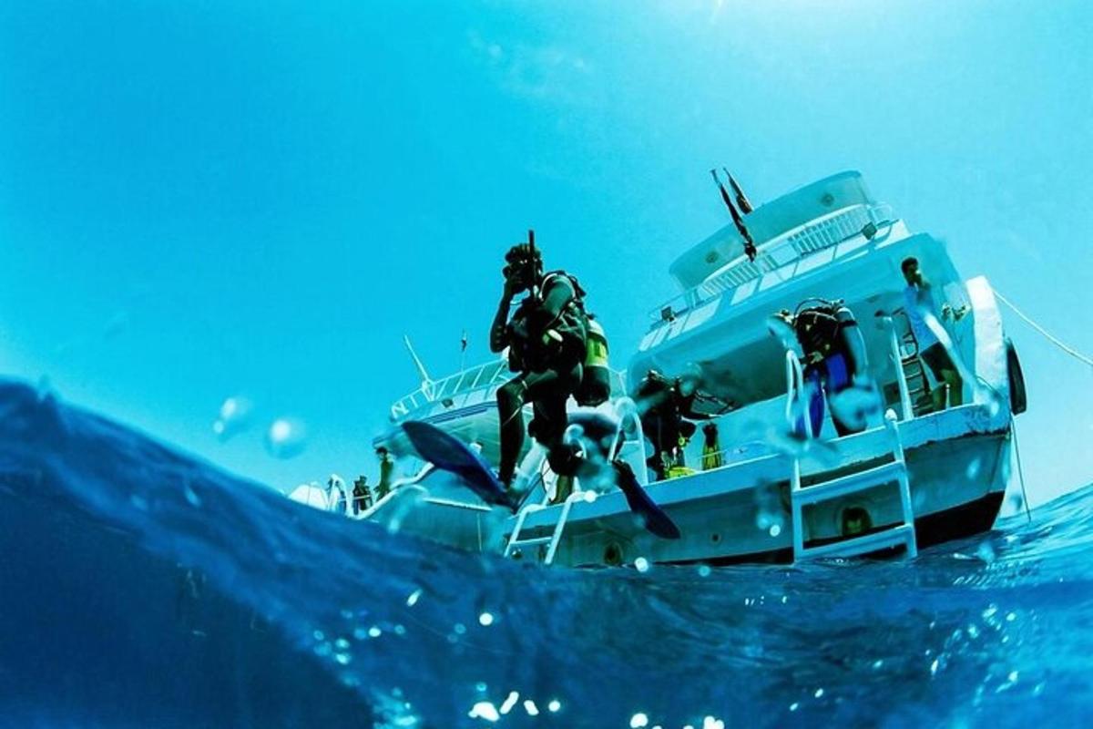 a man jumping off of a boat in the ocean