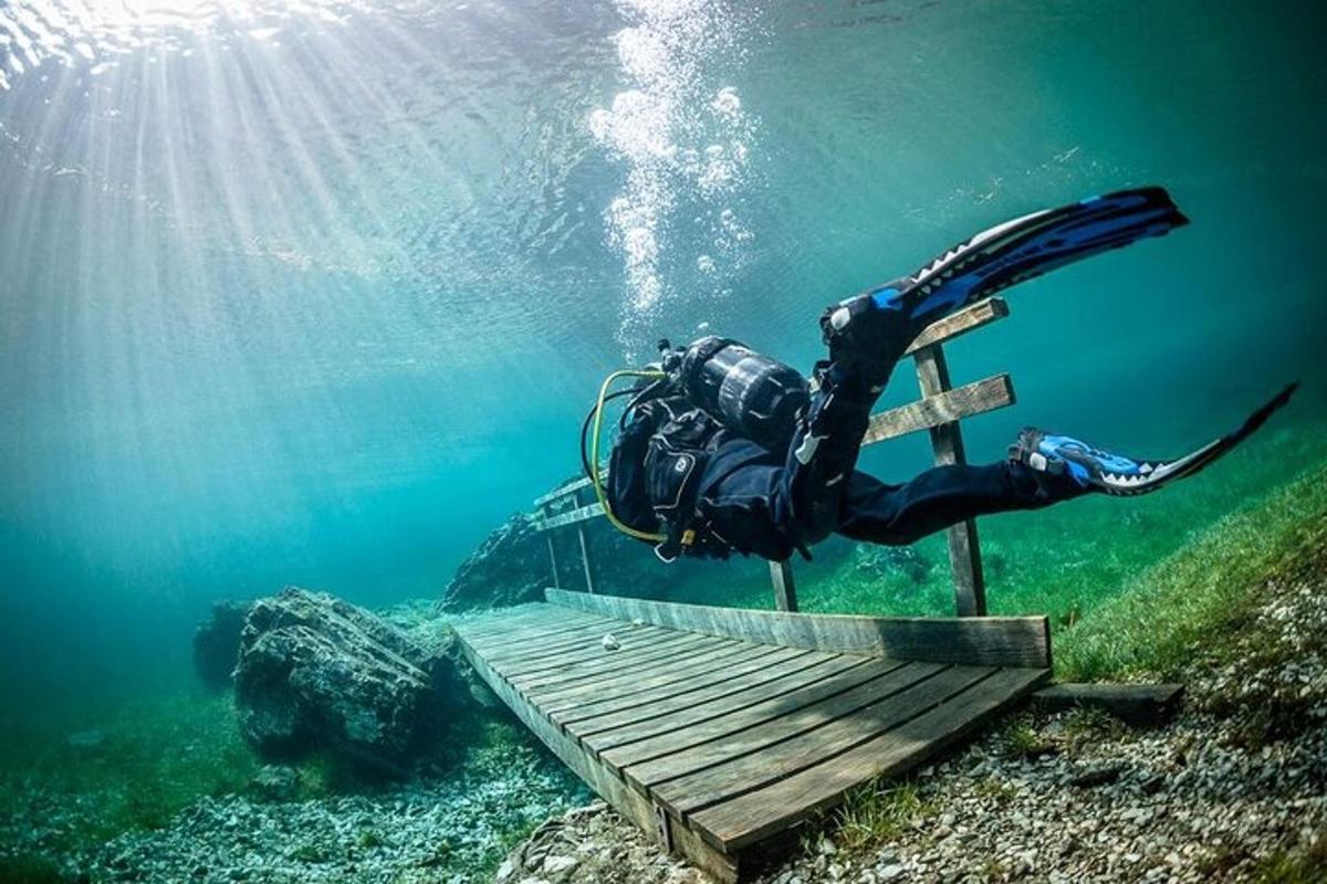 a diver in the water next to a wooden platform in the water