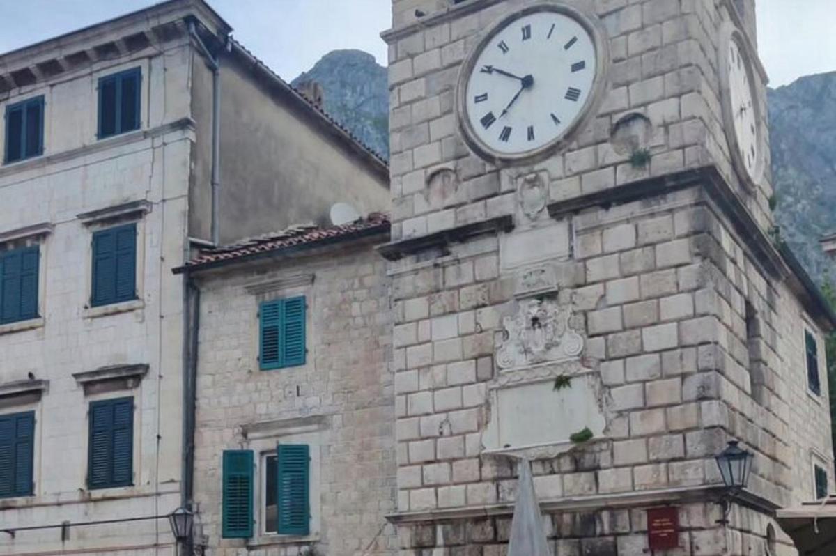 un rellotge al costat d'un edifici de maó