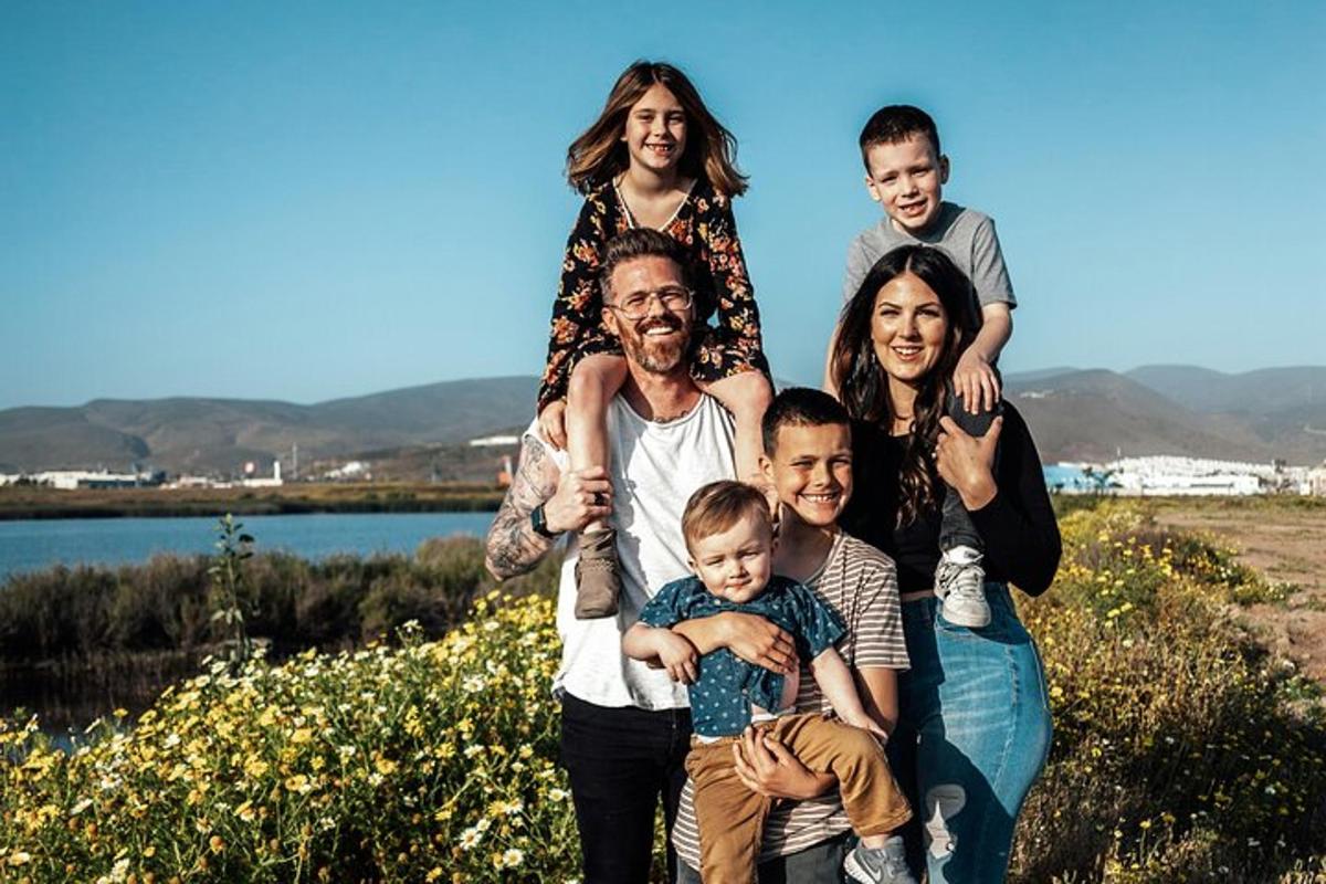 eine Familie posiert für ein Foto vor einem See