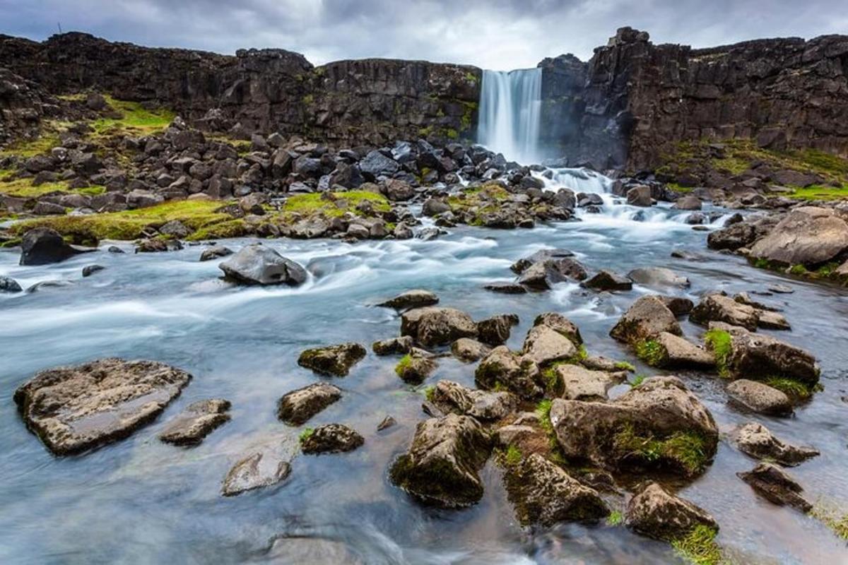 una cascata di fronte a un fiume con rocce