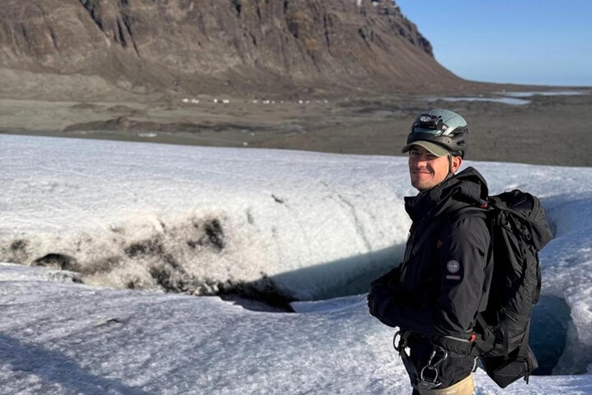 un uomo in piedi in cima a un campo coperto di neve