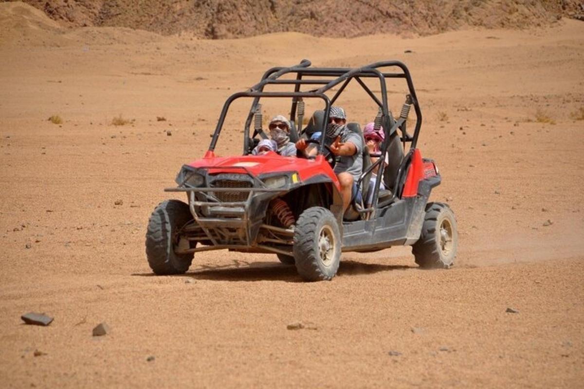 un grup de oameni care călătoresc cu un ATV în deșert