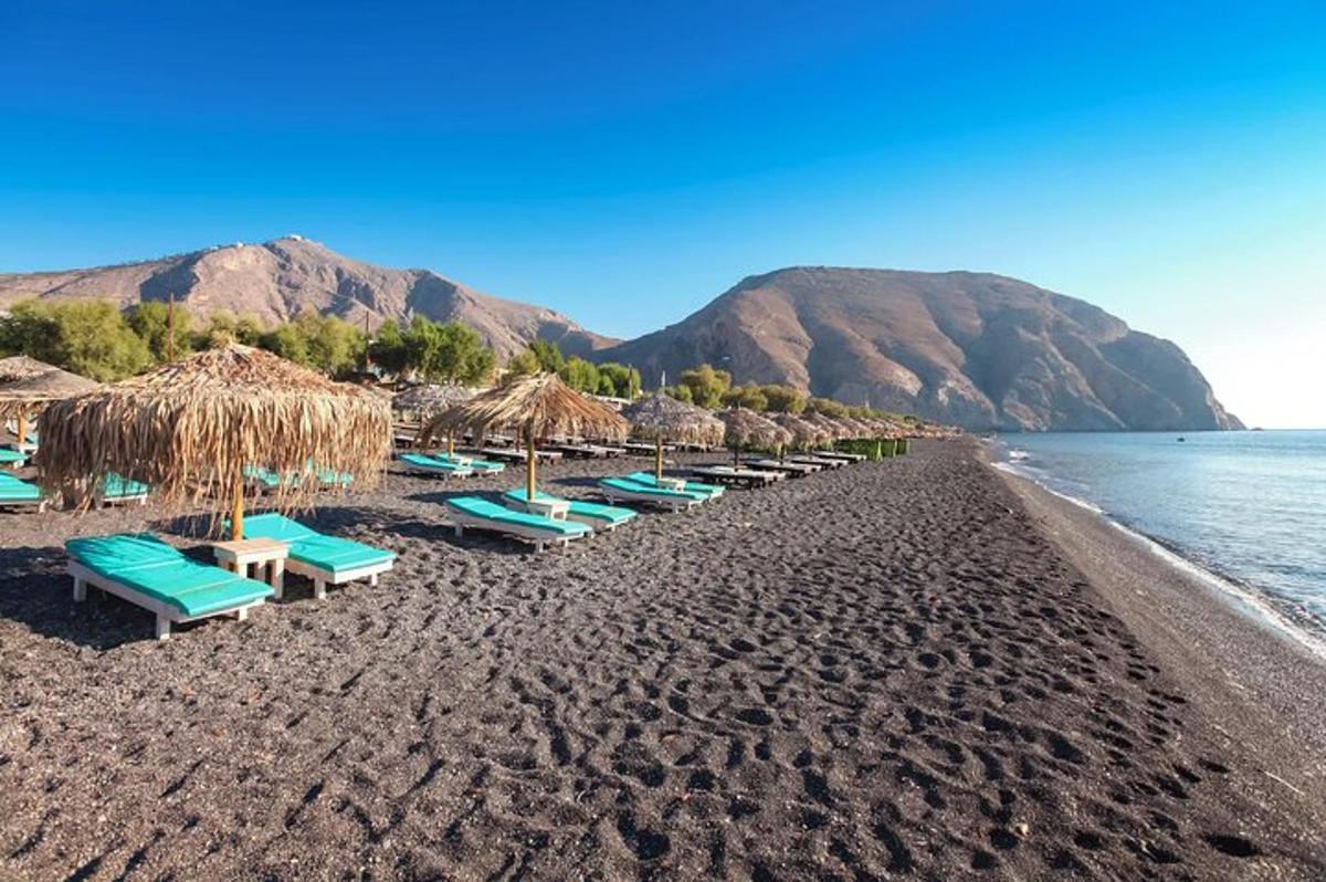 egy strand székekkel, szalma napernyőkkel és a vízzel