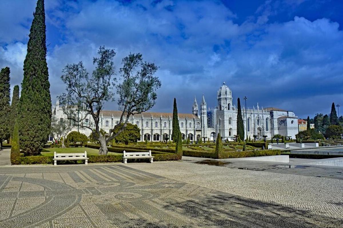 a large white building with two benches in a park