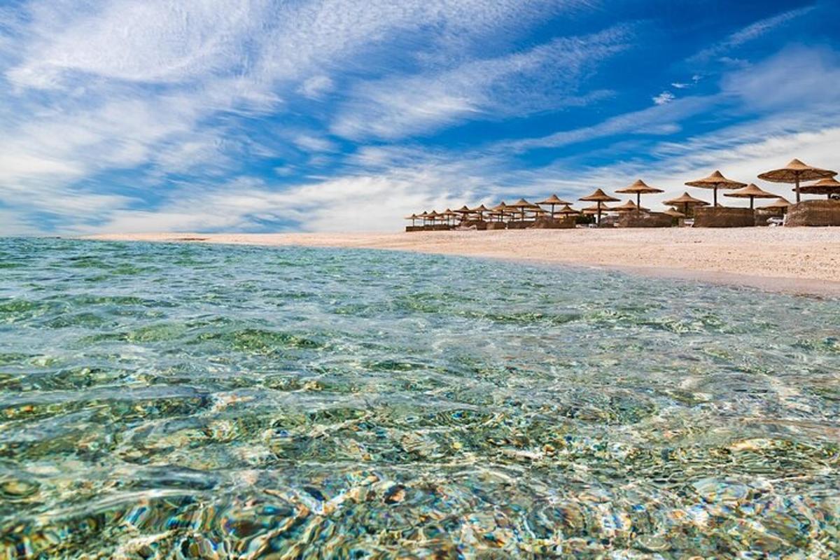ein Strand mit Sonnenschirmen und kristallklarem Wasser