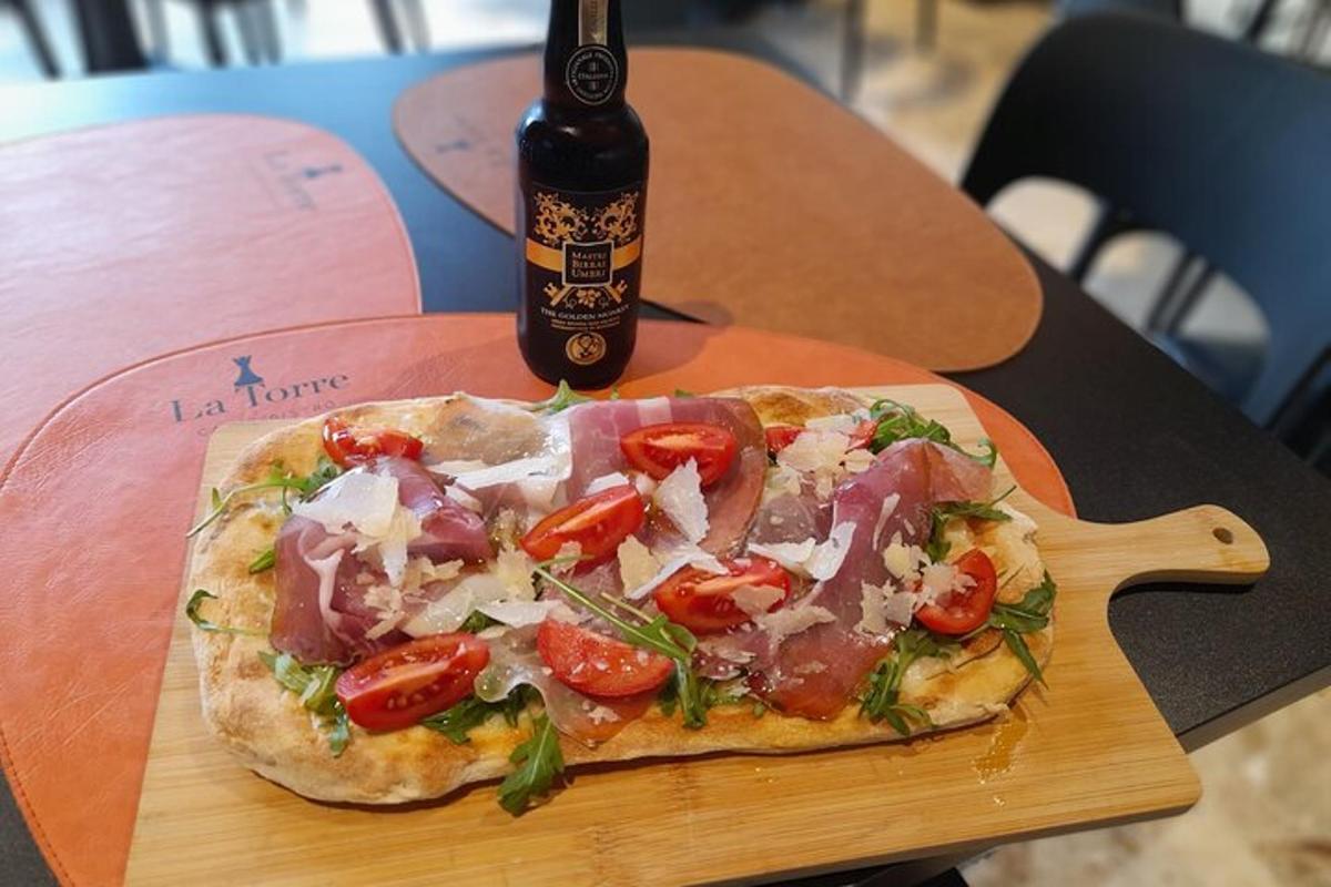 egy pizza egy fa vágódeszkán egy üveg sörrel