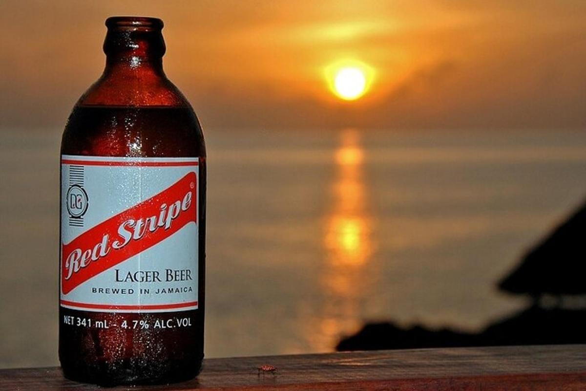 una bottiglia di birra appoggiata su un tavolo di fronte all'oceano
