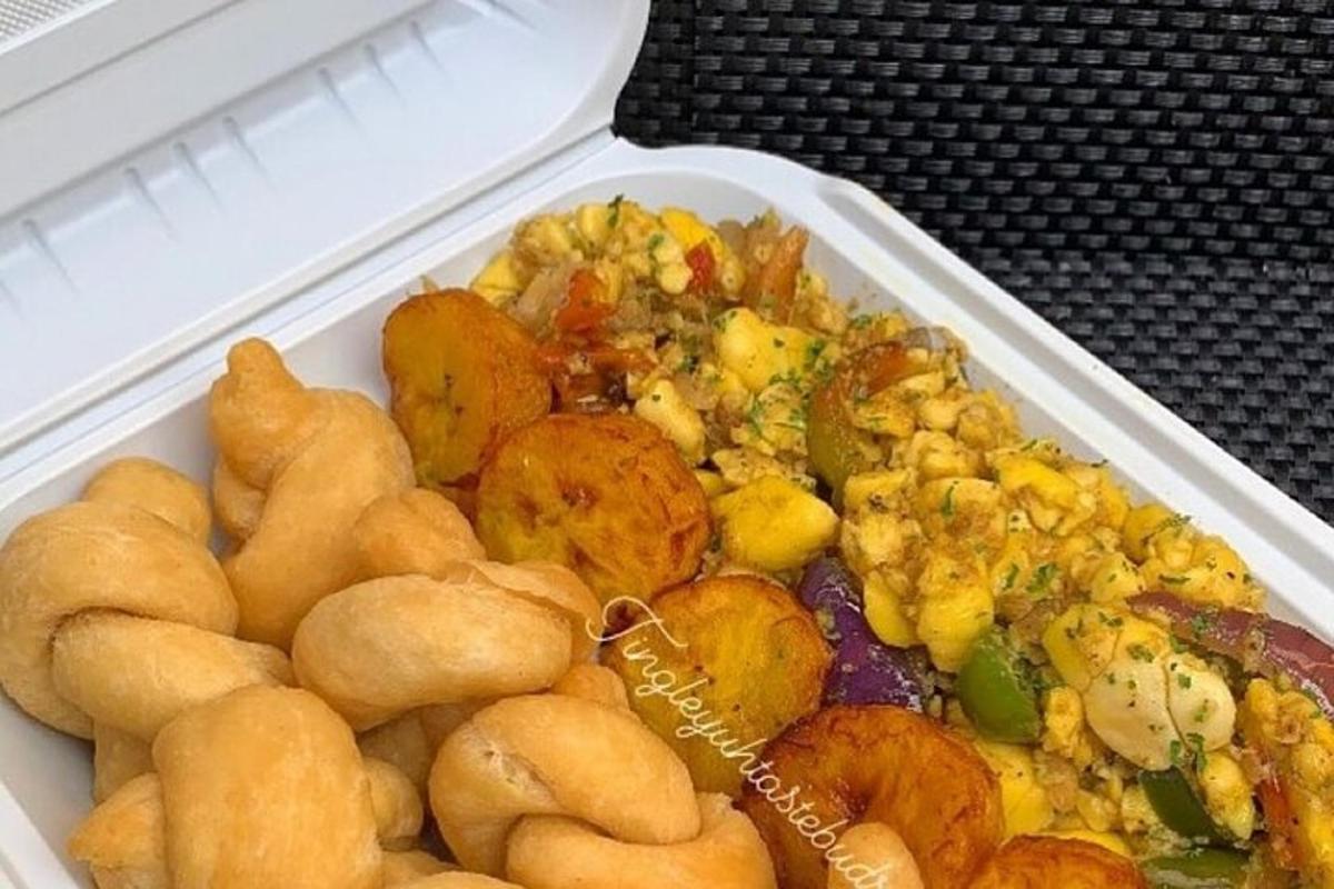 Un recipiente de poliestireno lleno de comida en una mesa.
