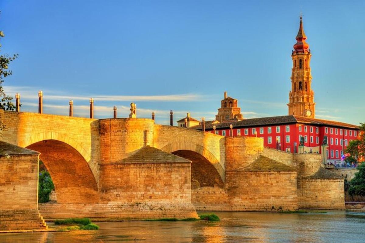 a bridge over a river with a building and a clock tower