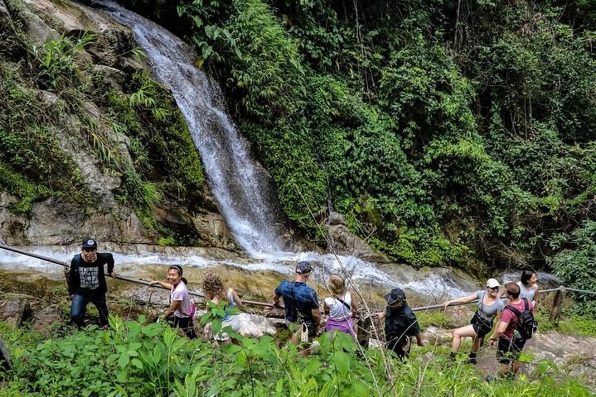 sekumpulan orang berdiri di hadapan air terjun
