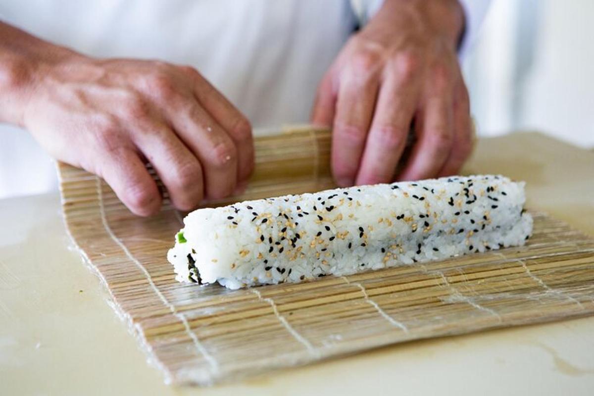 člověk připravuje sushi na prkénku