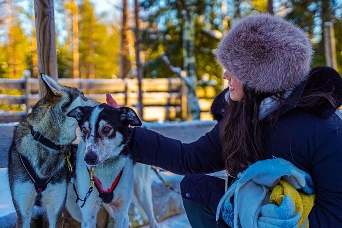 eine Frau streichelt einen Hund im Schnee