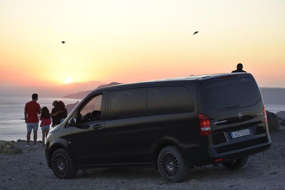 sebuah van hitam diletakkan di tepi pantai dengan orang ramai melihat matahari terbenam