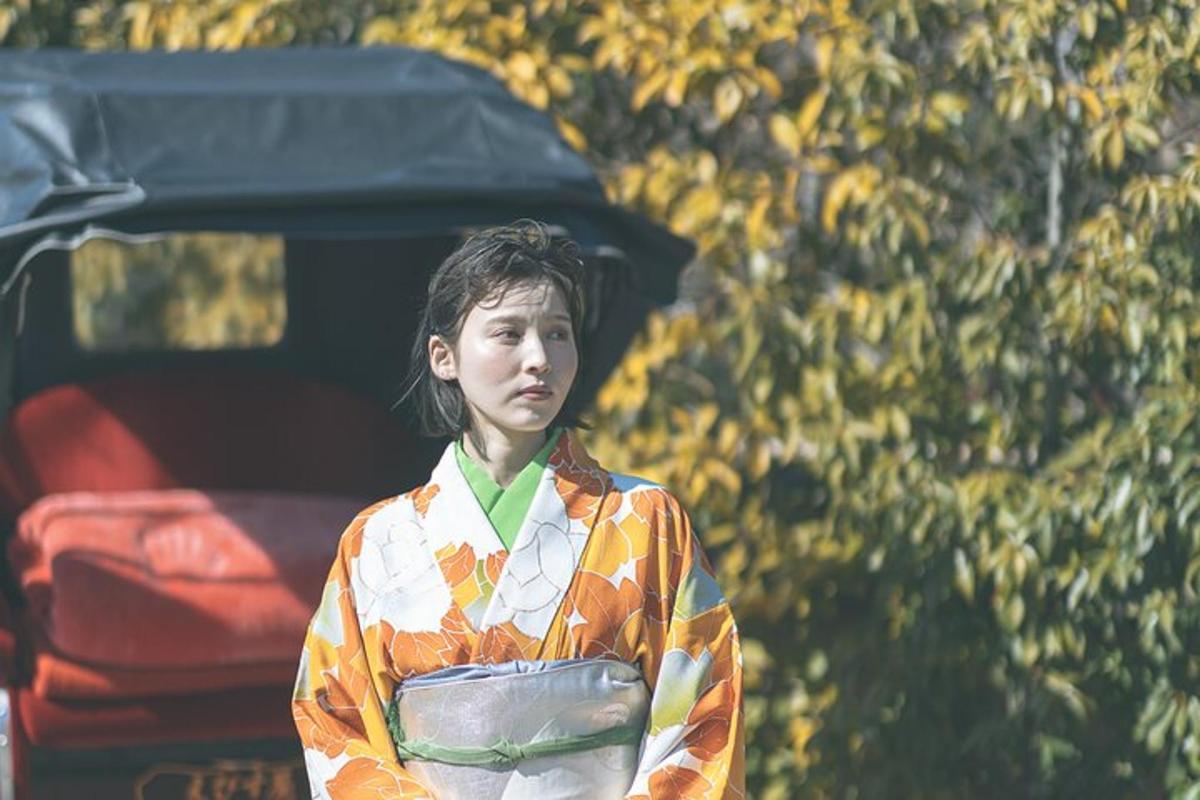 una donna che indossa un kimono in piedi davanti a un'auto
