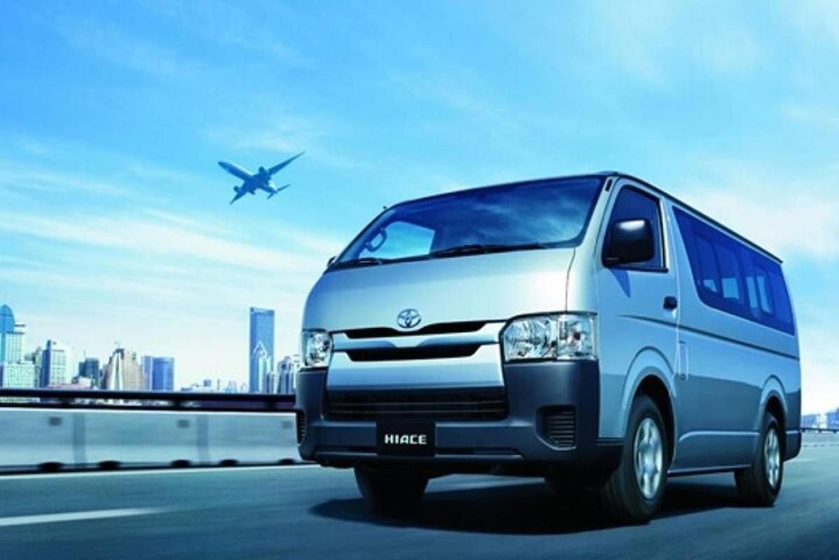 a van is driving on a highway with an airplane