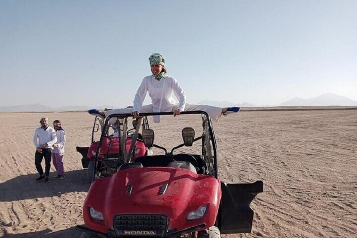 un bărbat care stă lângă o mașină de golf în deșert
