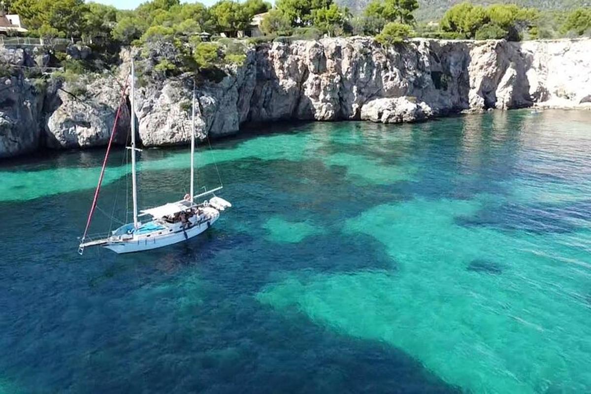 un barco en el agua junto a un acantilado