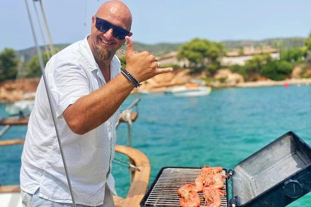 un homme debout à côté d'un barbecue avec de la viande