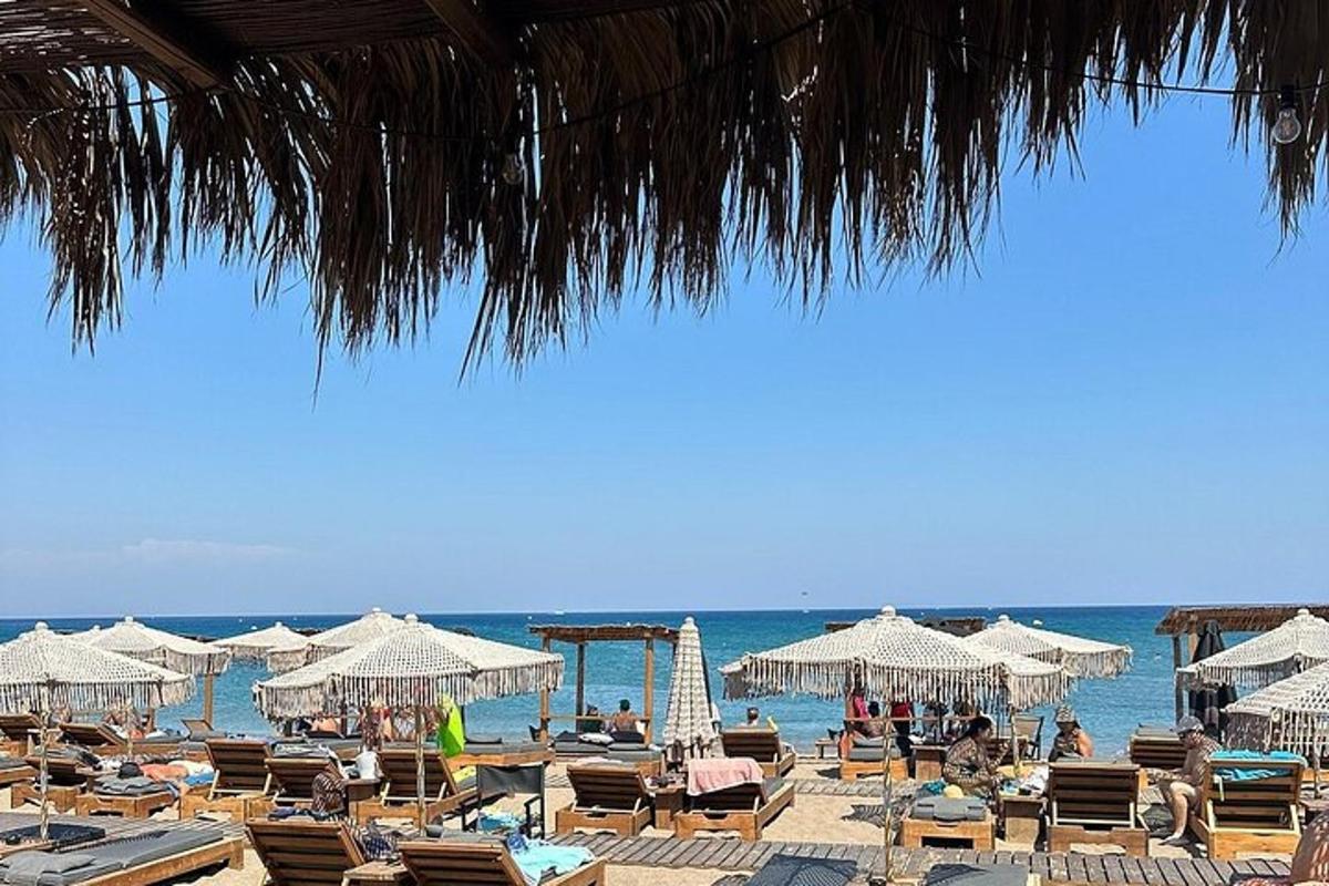 una platja amb gandules i para-sols i l'oceà