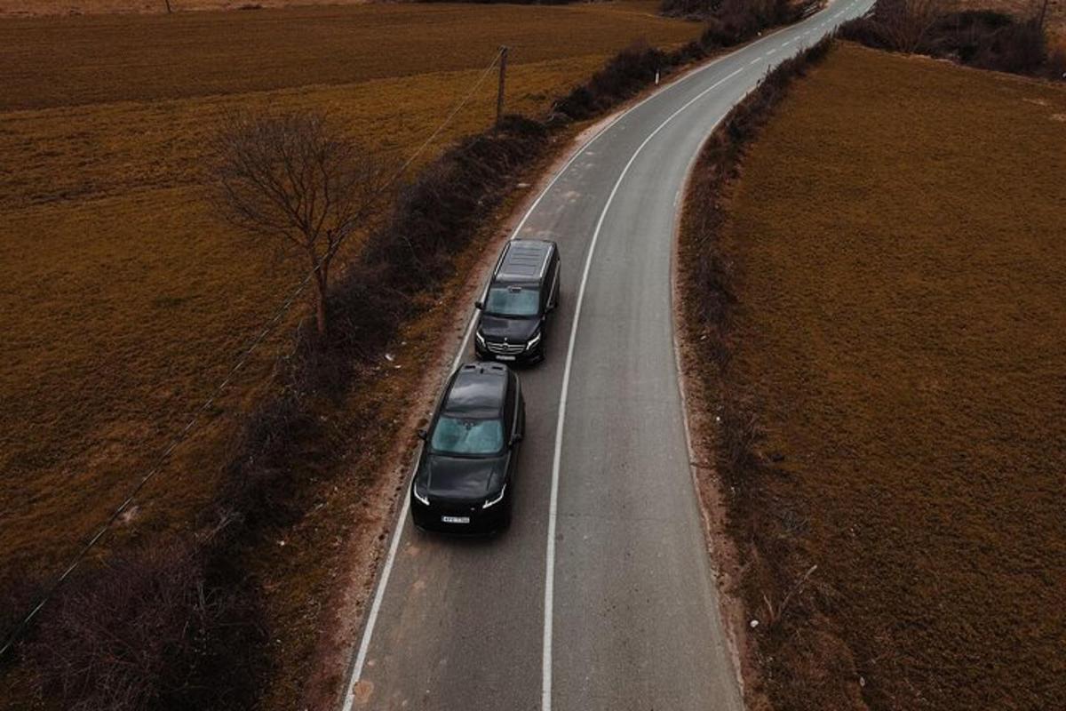 három autó halad végig egy mező melletti úton