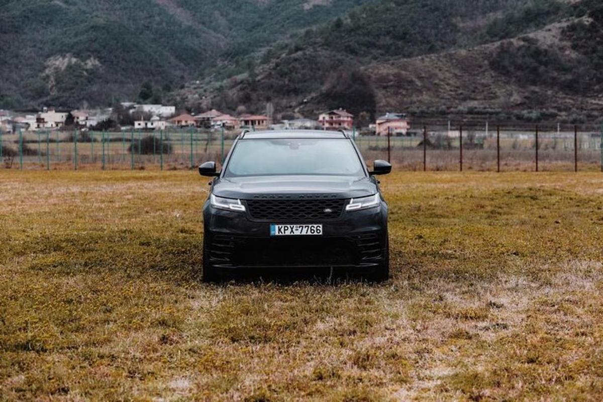 egy fekete autó parkolt egy füves mezőn