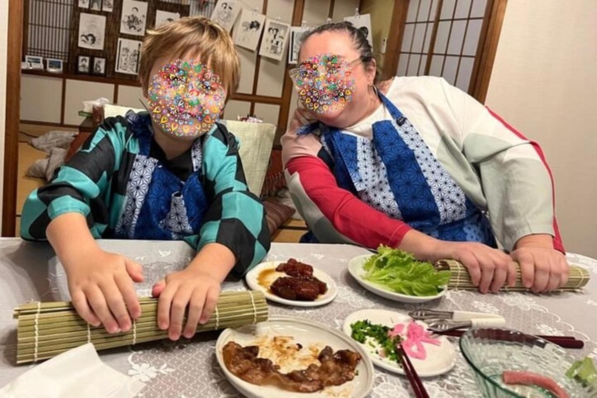 moški in dekle sedita za mizo z maskami na obrazu