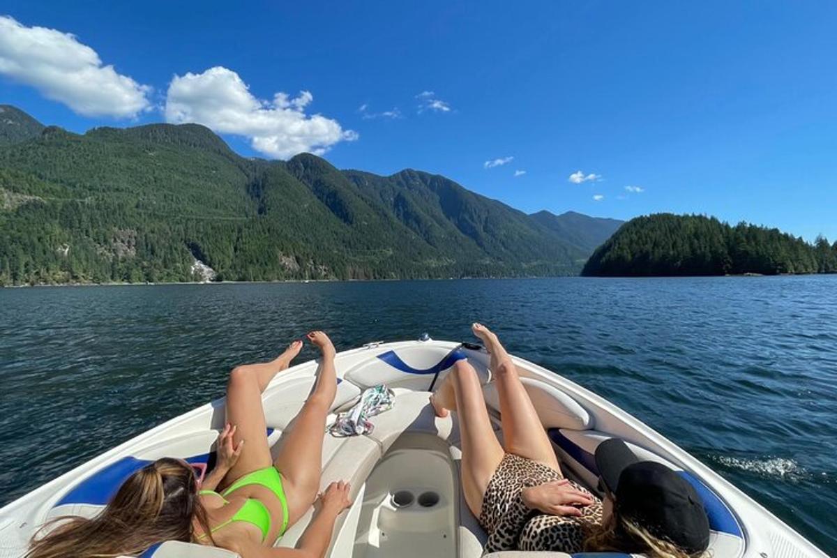 tre donne sdraiate sul retro di una barca su un lago