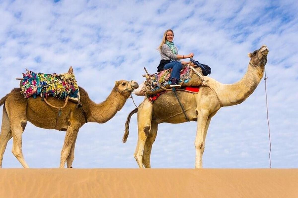 una mujer montada en un camello en el desierto