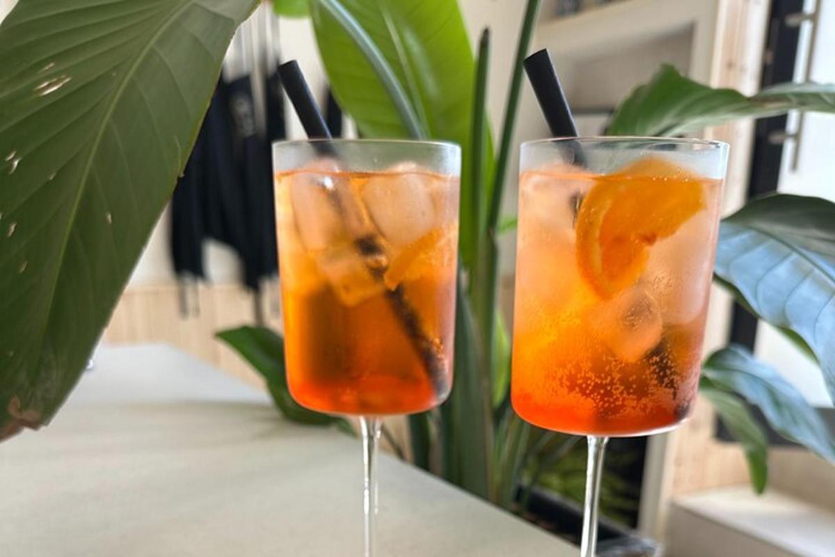 two glasses of orange juice sitting on a table