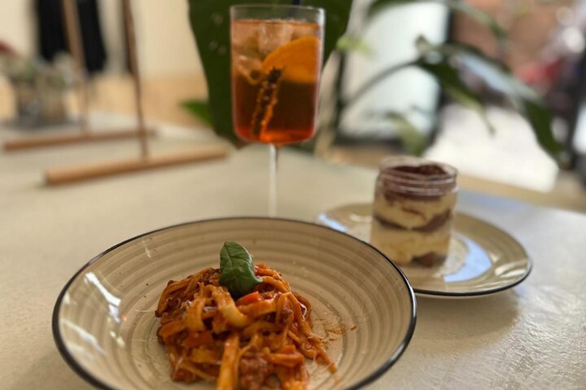 a plate of pasta and a drink on a table