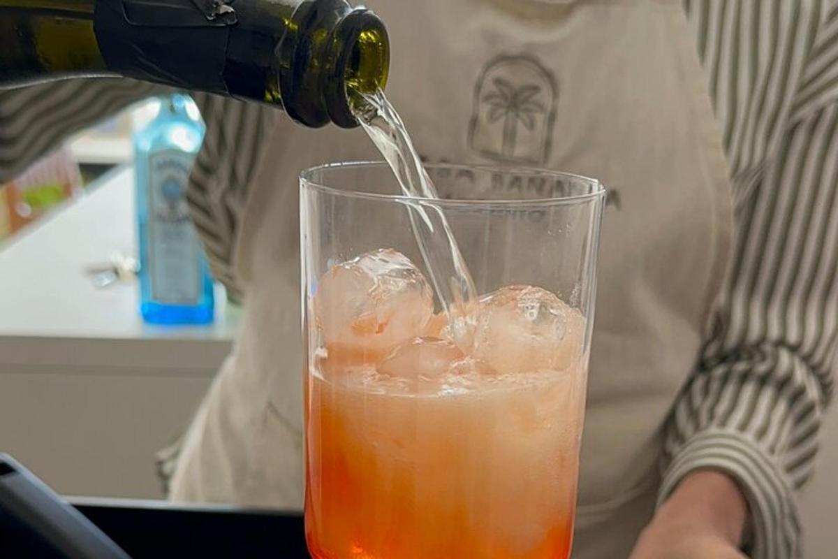 a person is pouring a drink into a glass