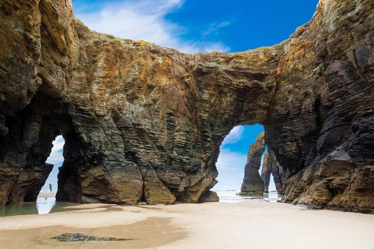 an arch in a rock wall on a beach