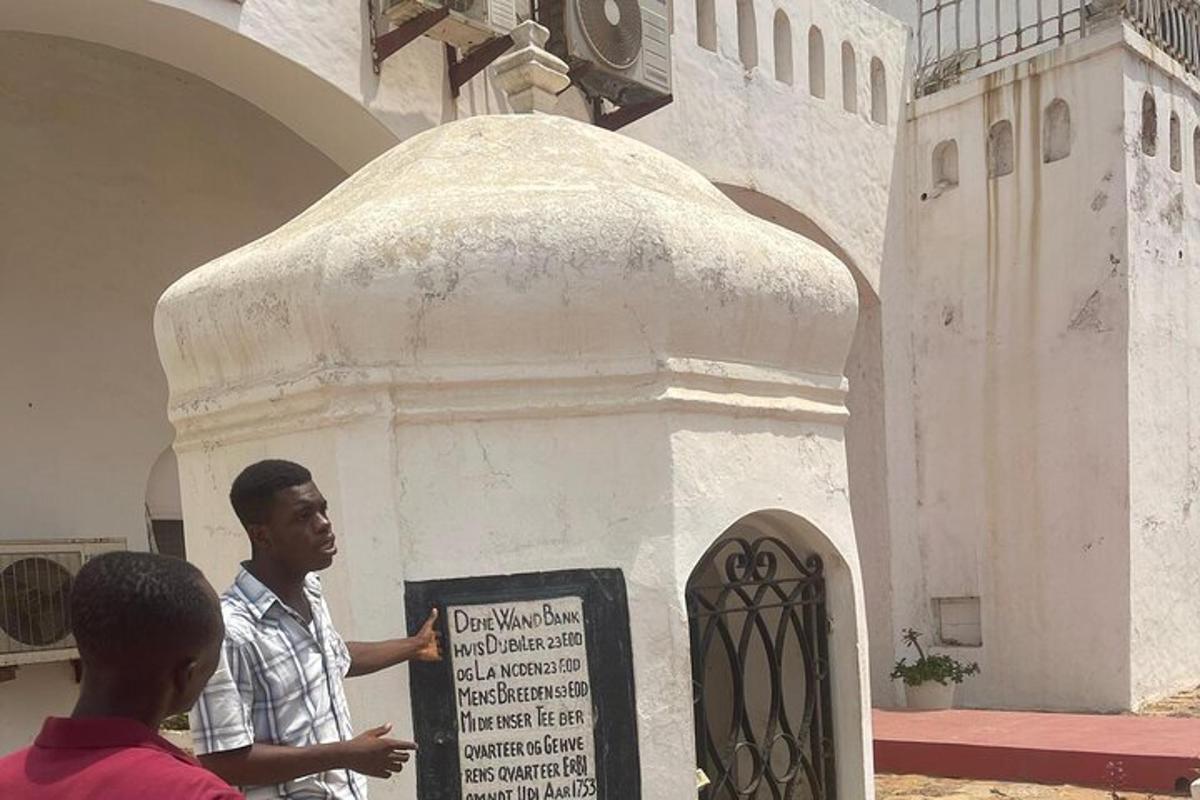 Un hombre parado frente a un edificio con un cartel.