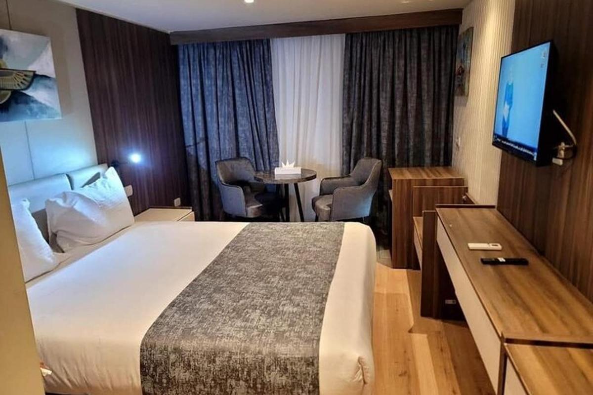 bilik hotel dengan katil dan tv skrin rata