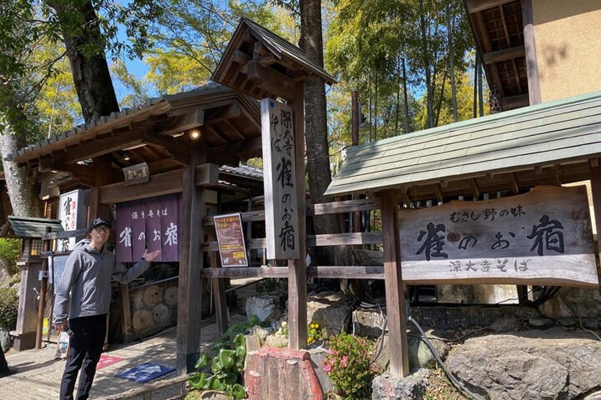 看板を持って建物の前に立っている男性