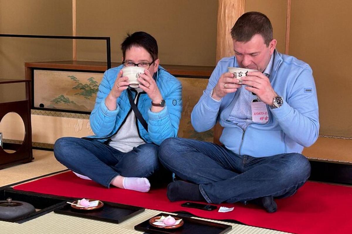 dois homens sentados no chão tirando fotos com seus celulares