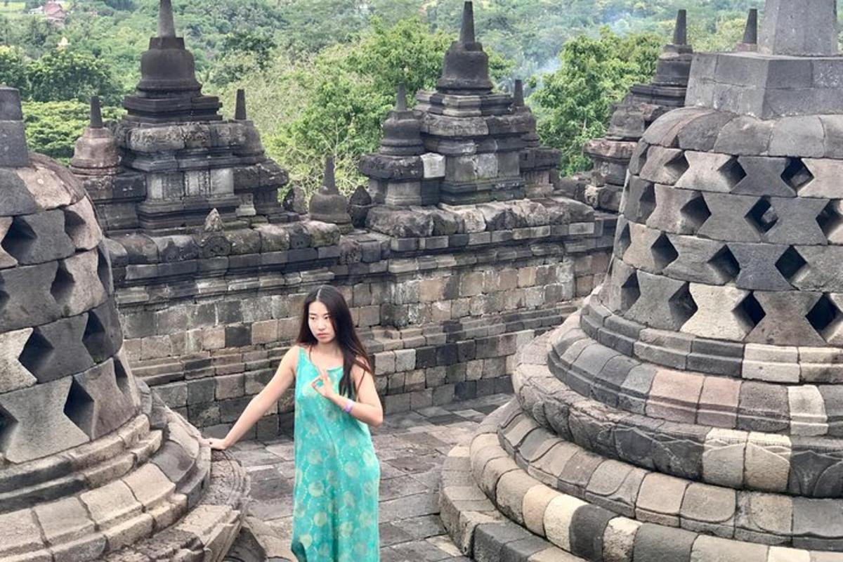 一位身穿绿色连衣裙的女子站在一栋建筑前