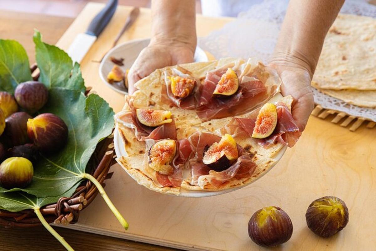 en person som holder en pai med bacon og fiken på
