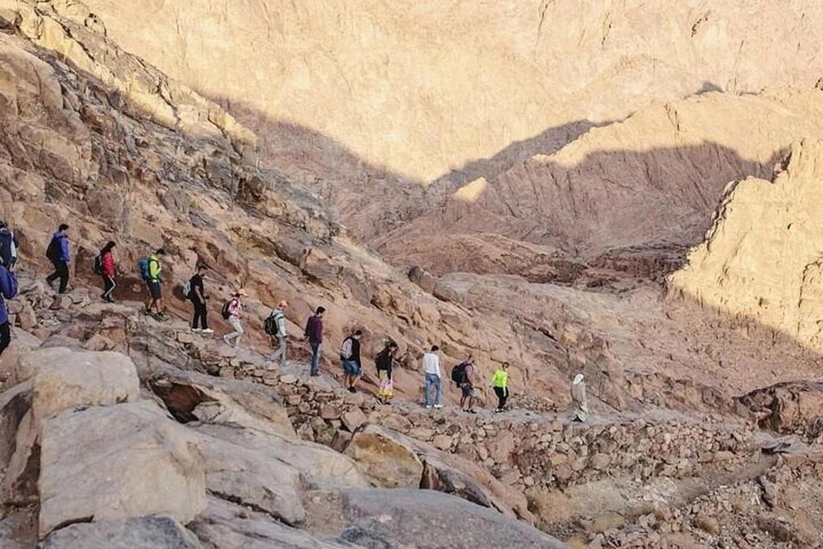 un gruppo di persone che camminano su una montagna rocciosa