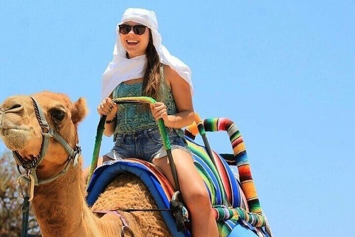 a woman riding on the back of a camel