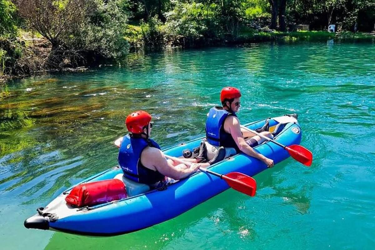 dva muži v modrém voru na řece