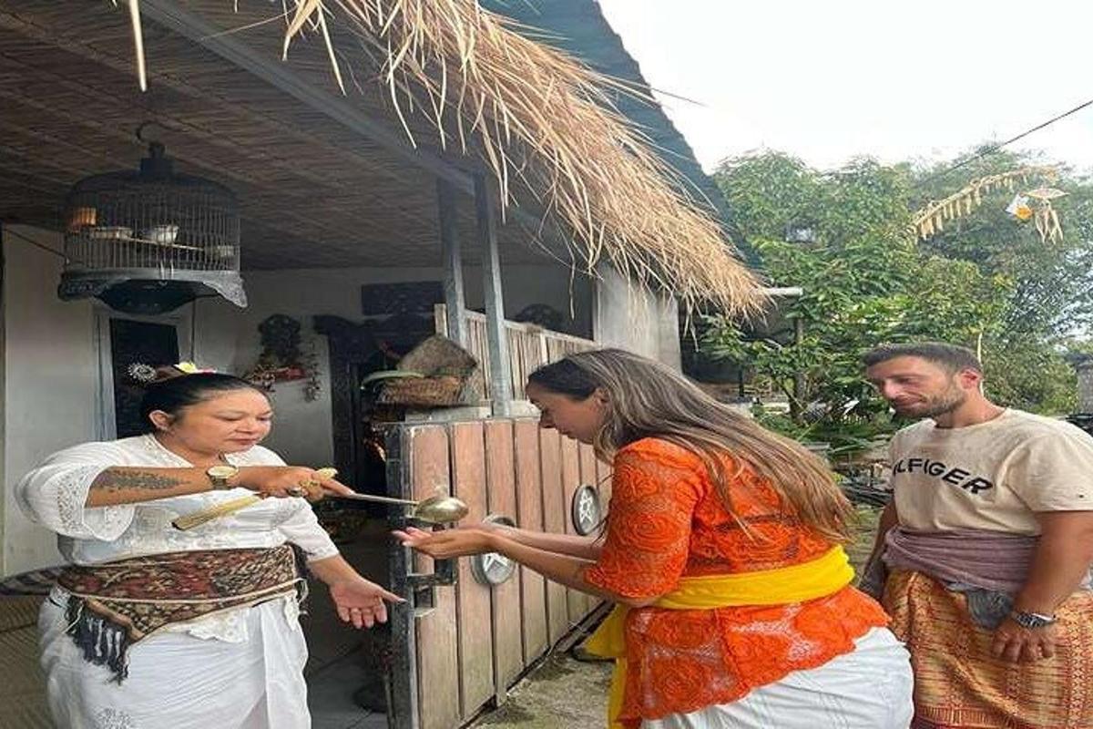 dua wanita dan seorang pria berdiri di luar rumah
